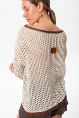 Sweater marrón de tejido calado con lurex en cuello, puños y ruedo. El escote puede usarse de dos formas: mostrando un hombro o de forma clásica.