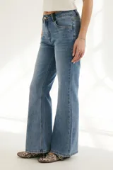 Pantalón de jean celeste de corte semi oxford, con detalles de cuero en pretina y bolsillos.