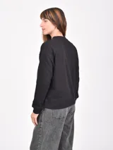 Buzo negro de manga larga con cuello redondo y puños y ruedo acanalados.