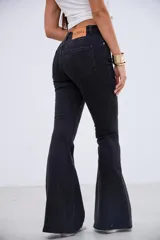 Pantalón de jean estilo oxford en color negro, con tiro medio-alto y costuras verticales frontales que estilizan la silueta.
