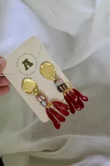 Aros colgantes con base dorada, cuentas de cristal y colgantes de resina roja.