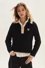 Sweater de punto con diseño de ochos, cuello polo con cierre de botones y detalles en contratono en cuello, puños y ruedo. Presenta un bordado en el pecho.