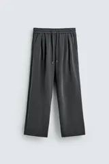 Pantalón jogger de corte wide fit confeccionado en tejido fluido con viscosa. Presenta un efecto lavado, cintura elástica ajustable con cordón, pliegues frontales, bolsillos laterales y un bolsillo trasero de plastrón.