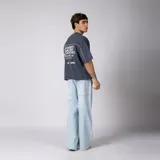 Remera gris oscuro de corte boxy, manga corta amplia, con cuello redondo y diseño gráfico frontal con la palabra "CONCEPTO" delineada en blanco dentro de un panel horizontal.