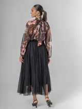 Falda estilo ballet core confeccionada en gasa negra con pequeños destellos que aportan brillo sutil y movimiento. Tiene cintura elastizada.