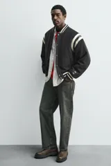 Bota tipo Chelsea de cuero color marrón oscuro, con paneles elásticos laterales, tirador trasero y suela track con volumen.