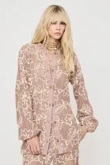 Camisa de manga larga color rosa con diseño estampado en tono crudo, cuello mao y cierre frontal con botones.