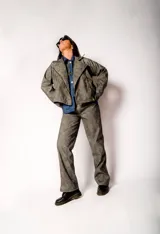 Chaqueta gris con cierre frontal y cuello solapa.