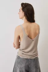Blusa de punto color marrón chocolate con escote en V y breteles finos, de caída suave y textura tejida con sutil brillo.