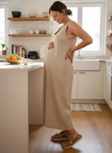 Mono largo color beige, de corte suelto y sin mangas.