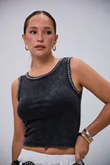 Musculosa negra con efecto acid wash y diseño al cuerpo, con detalles de tachas metálicas plateadas alrededor del cuello y las sisas.