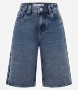 Bermuda tipo jorts de jean azul con lavado medio, corte holgado y largo por debajo de la rodilla. Presenta cintura con trabillas, bolsillos laterales y traseros, y cierre frontal con botón y cremallera.