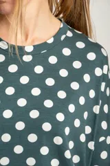 Remerón verde con lunares blancos, de calce oversize y mangas cortas.