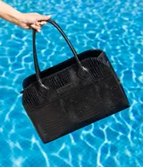 Bolso tipo tote de cuero negro con textura tipo piel de cocodrilo, doble asa de mano y cierre superior con cremallera.
