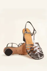 Sandalia de cuero negro con tiras cruzadas en el empeine, diseño en T con tira ajustable al tobillo y taco cuadrado.