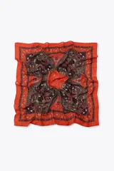 Pañuelo cuadrado de diseño estampado con motivos paisley y florales en tonos rojos, naranjas y negros, con borde decorativo.