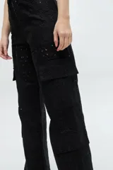Pantalon cargo de tiro medio confeccionado en lino broderie negro, con bolsillos laterales tipo cargo y diseño de pierna ancha.