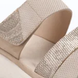 Sandalias de plataforma baja con dos tiras anchas en el empeine, una de ellas con ajuste de velcro. Presentan una combinación de texturas en tonos beige y detalles metalizados, con plantilla acolchada y suela de goma blanca.