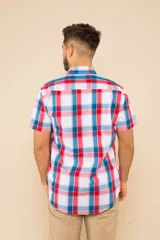 Camisa de manga corta con estampado de cuadros en tonos verdes, azules y blancos. Presenta cuello clásico, cierre frontal con botones y dos bolsillos delanteros con solapa.