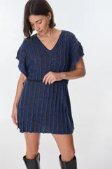 Vestido corto de tejido de punto con cuello V y mangas cortas, con diseño de rayas verticales en tonos azul oscuro y negro, con hilos de lurex que le dan brillo. Se ajusta a la cintura con un lazo fino negro.