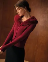 Cardigan de tejido acanalado color bordó, con cuello de piel sintética al tono, cierre frontal con botones y diseño entallado de manga larga.