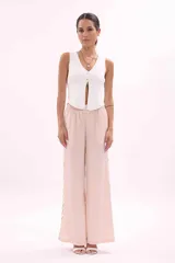 Chaleco tejido de punto color blanco, sin mangas, con escote en V y cierre frontal con botones dorados.