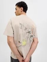 Remera color crema de corte recto y mangas cortas, con cuello redondo. Estampado en la espalda con un dibujo de una calle con edificios, palmeras y un auto amarillo.