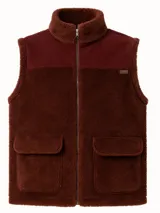 Chaleco marrón con cuello alto, cierre frontal con cremallera, dos bolsillos delanteros y forro de tela suave.