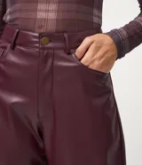 Pantalón de corte barrel confeccionado en poliuretano, con cintura alta, trabillas para cinturón, bolsillos funcionales y cierre frontal con botón y cremallera.