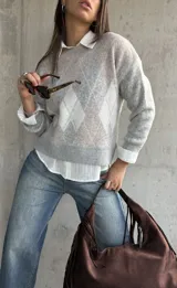 Sweater de punto con diseño de rombos en tonos gris y beige, cuello redondo, mangas largas y puños acanalados.