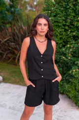 Conjunto de chaleco con botones y bermuda de crepé color rojo. El chaleco es sin mangas y con escote en V. La bermuda es de tiro alto y corte holgado.