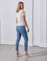 Blusa color blanco de crepe, marca Cable & Gauge. Cuello halter con detalles plisados y mangas cortas de encaje con destellos brillantes.