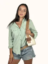 Bolso tipo baguette color crudo con doble correa al hombro de cuero color camel.