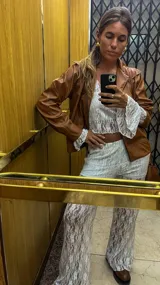 Campera marrón de cuero sintético con cierre frontal, cuello camisero y costuras decorativas en hilo blanco.