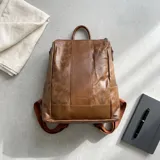 Mochila Hanauma de eco-cuero marrón con acabado texturizado, asa superior y correas de hombro ajustables de tela resistente. Cuenta con bolsillos laterales y cierre superior.