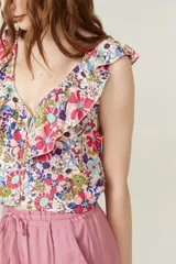 Blusa cropped con estampado multicolor, cuello redondo, sin mangas y volados en los hombros.