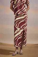 Falda midi de algodón con estampado de cebra en rojo y blanco, corte recto y abertura lateral.