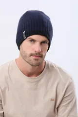 Gorro tejido de punto reversible en dos colores, azul marino y negro, con etiqueta lateral de la marca.