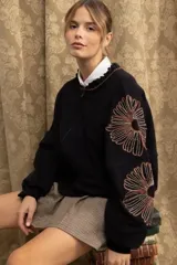Campera bomber de jogging color marrón, con cierre frontal y bordados florales en las mangas.