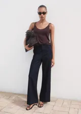 Pantalón wide leg de tiro alto en tejido de algodón estilo denim, color azul marino, con trabillas, cuatro bolsillos y cierre oculto con botón, gancho y cremallera.