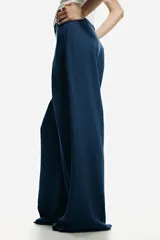 Pantalón sastrero de tiro alto y perneras amplias en color azul, con pinzas delanteras y traseras marcadas, y trabillas para cinturón.