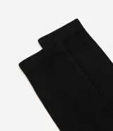Media de caña larga color negro, de diseño básico y tejido suave y elástico.