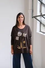 Remera de algodón color chocolate con cuello redondo, mangas largas y estampa frontal de flores en tonos plateado y dorado.