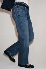 Jeans de tiro bajo y corte recto, confeccionados en denim con efecto lavado. Presentan cintura con trabillas, bolsillos delanteros y traseros, y cierre frontal con cremallera y botón.