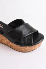 Sandalia color beige con plataforma de corcho y tiras cruzadas de cuero.