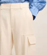 Pantalón wide leg color beige confeccionado en sarga sastrería, de cintura alta, sin estampa y con bolsillos cargo en los laterales.