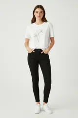 Remera de algodón de manga corta y cuello redondo, con diseño ajustado al cuerpo y detalle de estampado lineal de flores en el frente.