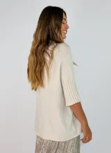 Sweater de punto color bordó, con cuello alto y mangas cortas con terminación acanalada.