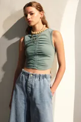Top verde agua al cuerpo sin mangas con frunces en el pecho y escote levemente en V.
