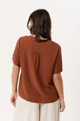 Blusa marrón de mangas cortas con cuello redondo y corte holgado.